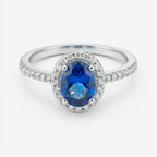 Anel Ivel em prata 925 com zircônia oval azul em halo de zircônias brancas e aro fino cravejado, vista frontal