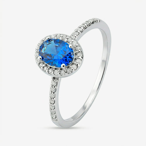 Anel Ivel em prata 925 com zircônia central oval azul, halo de zircônias brancas e fileira cravejada no aro até a metade da banda, vista lateral