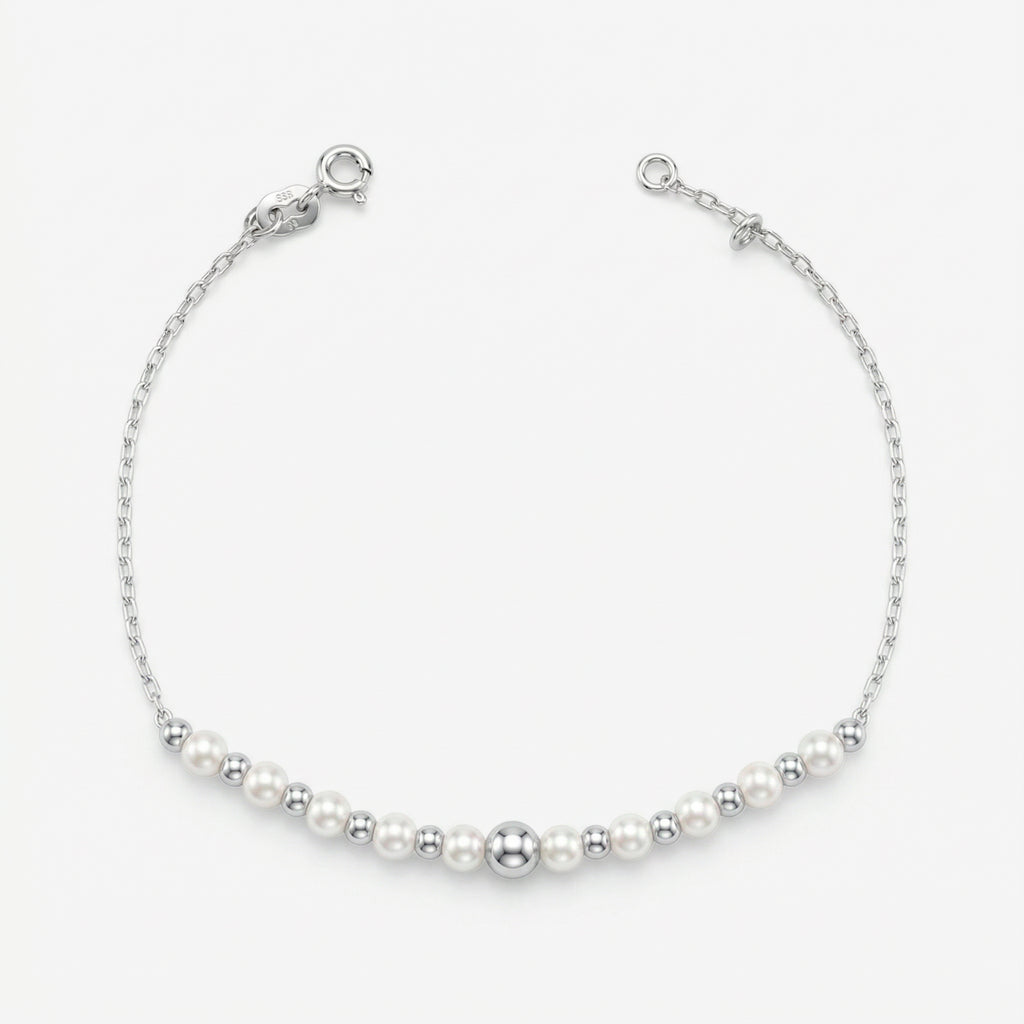 Pulseira Mara em prata 925 com sequência de pérolas sintéticas brancas e esferas polidas, corrente Cartier 030 e fecho boia com extensor regulável, vista superior