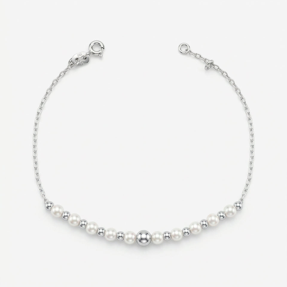 Pulseira Mara em prata 925 com sequência de pérolas sintéticas brancas e esferas polidas, corrente Cartier 030 e fecho boia com extensor regulável, vista superior